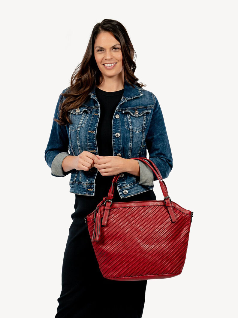 Woman in denim jacket holding red leather handbag