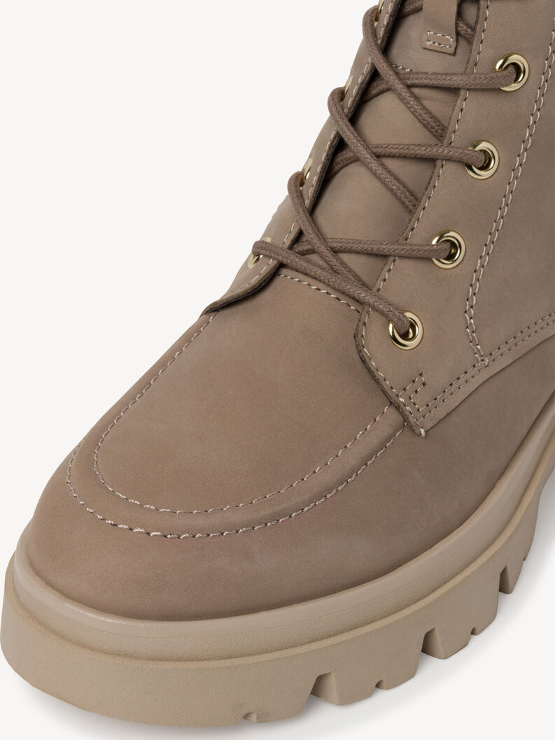 Close-up of laces and stitching on beige leather ankle boot