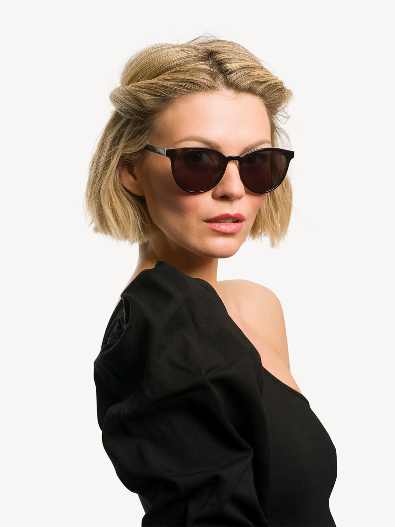 Woman wearing black round sunglasses with black top