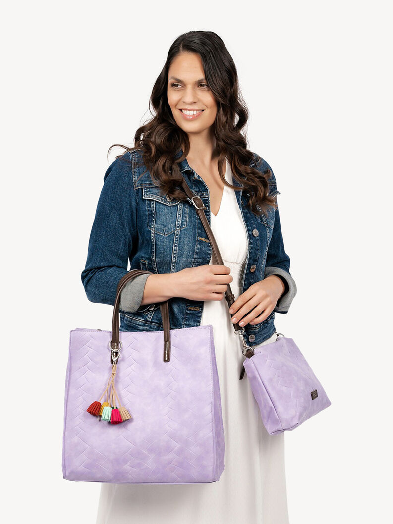 Frau h&auml;lt fliederfarbene Tasche und kleinere Crossbody mit bunten Quasten