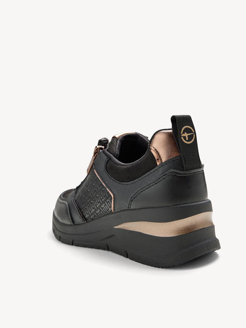 Zijaanzicht van zwarte sneakers met koperen details en logo