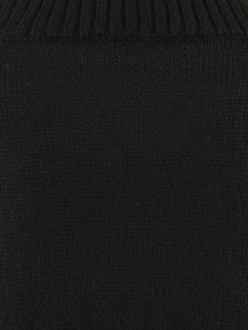 Close-up detail van zwarte gebreide trui met geribbelde afwerking