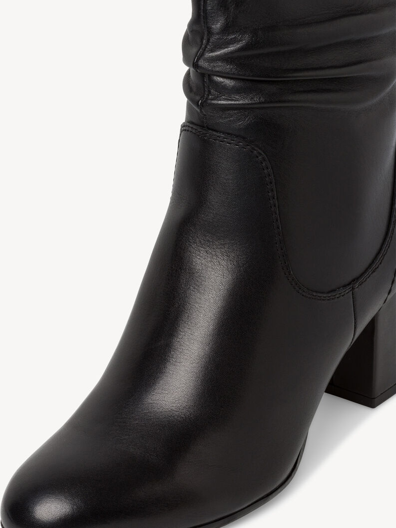 Detailn&iacute; pohled na hladkou texturu čern&yacute;ch kožen&yacute;ch kotn&iacute;kov&yacute;ch bot