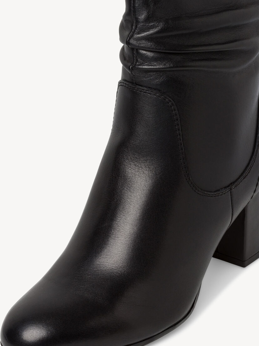 Close-up van gladde textuur zwarte leren enkellaarzen met stiksel