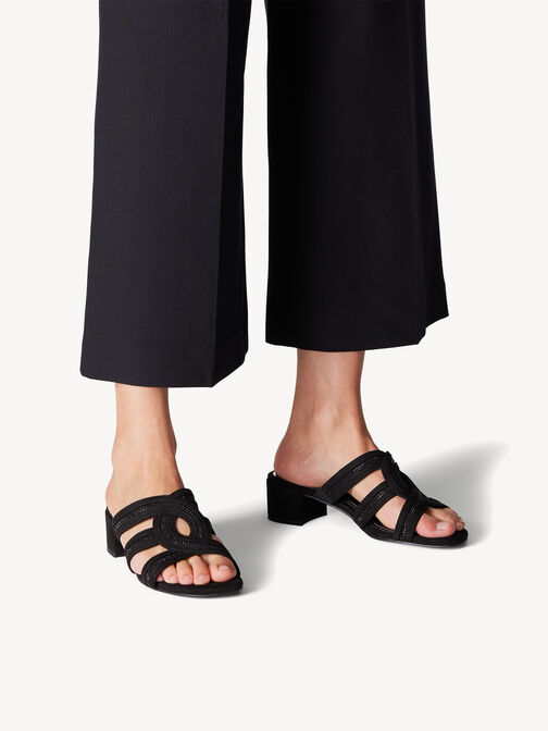 Schwarze Pantoletten mit niedrigem Absatz getragen von Model in schwarzer Hose