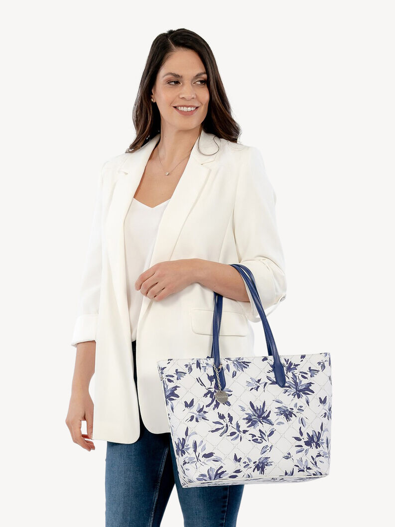 Frau h&auml;lt wei&szlig;e Blumen-Tasche mit blauen Griffen