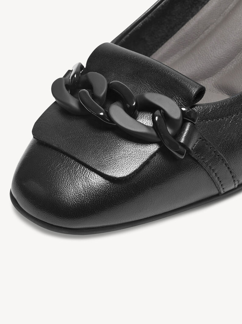 Nahaufnahme der dekorativen schwarzen Kette auf schwarzen Lederpumps