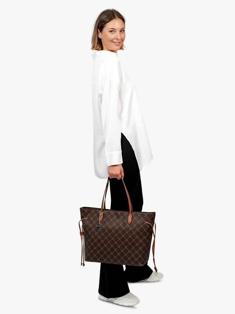 Frau h&auml;lt braune Shopper-Tasche mit Muster und Doppelhenkeln