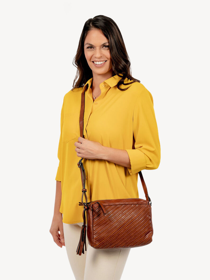 Femme en blouse jaune portant un sac bandouli&egrave;re en cuir marron