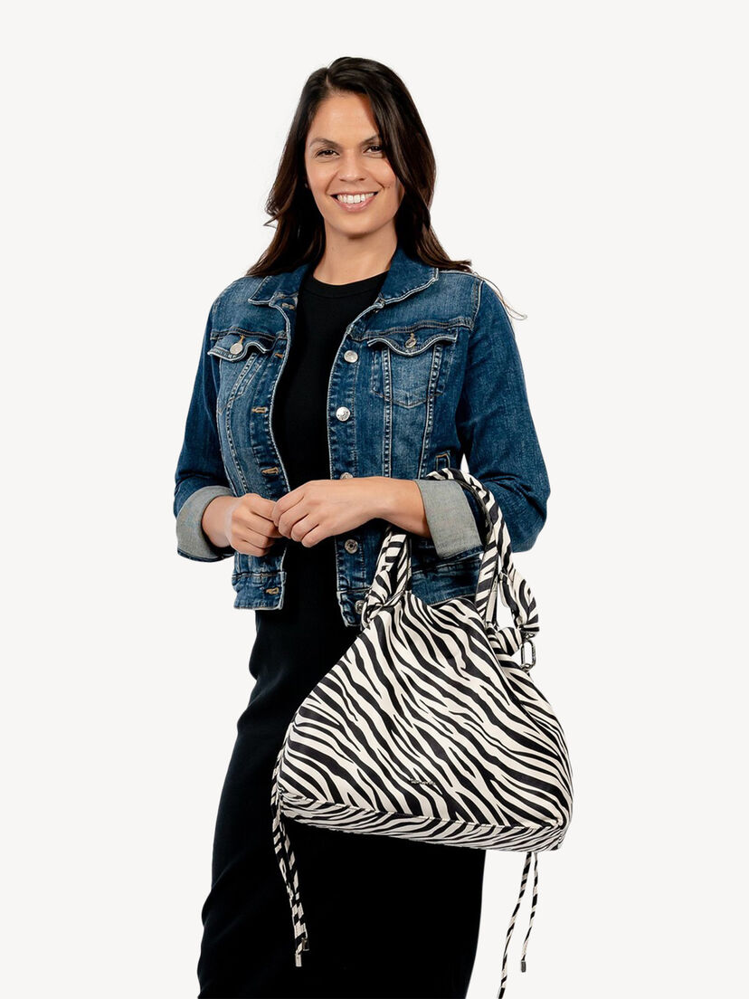 Vrouw draagt stijlvolle stoffen tas met zebraprint over schouder